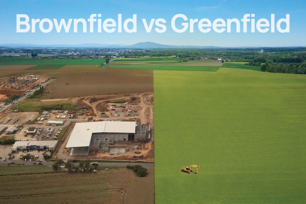 Aerial photograph of brownfield construction site next to a greenfield site ready to be developed by an escavator